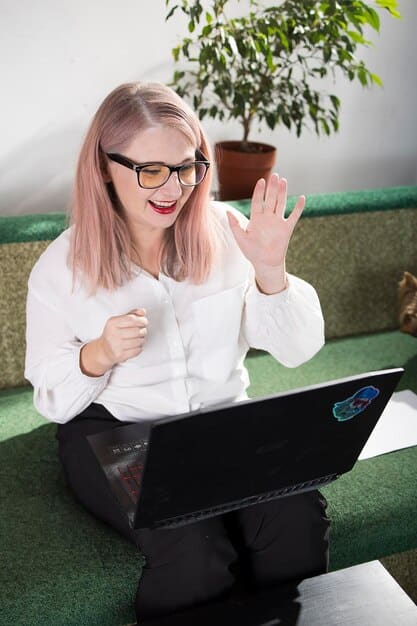 A person proudly displaying a blockchain certification on a laptop screen during a video call. The background shows a home office setup.