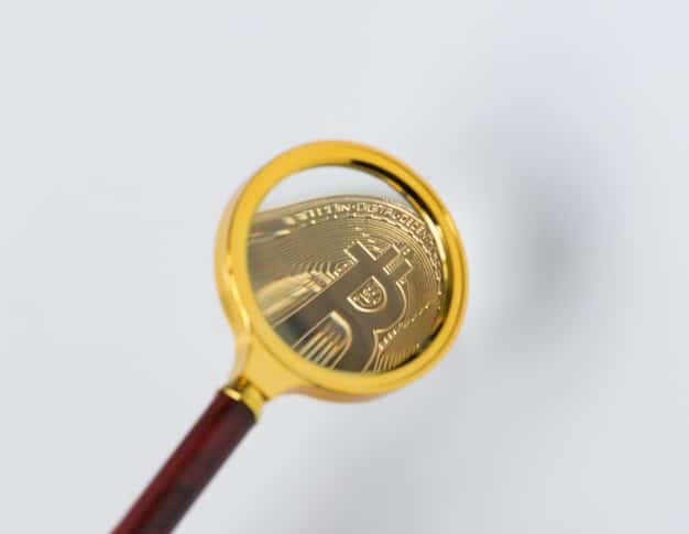 A conceptual image showing a magnifying glass over a cryptocurrency token, with the words 